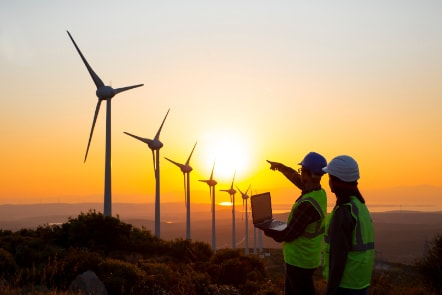 Sunset wind farm with workers